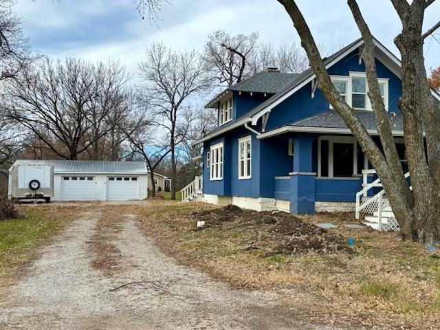 view of home's exterior featuring covered porch, an outdoor structure, and a garage