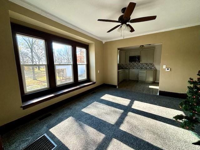 spare room with a healthy amount of sunlight, ceiling fan, and ornamental molding