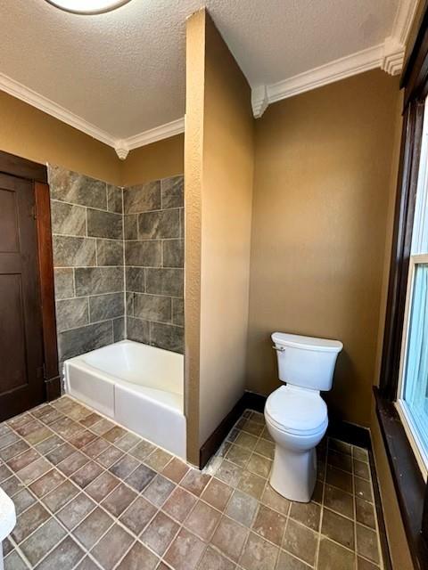 bathroom featuring a bath, a textured ceiling, toilet, and ornamental molding