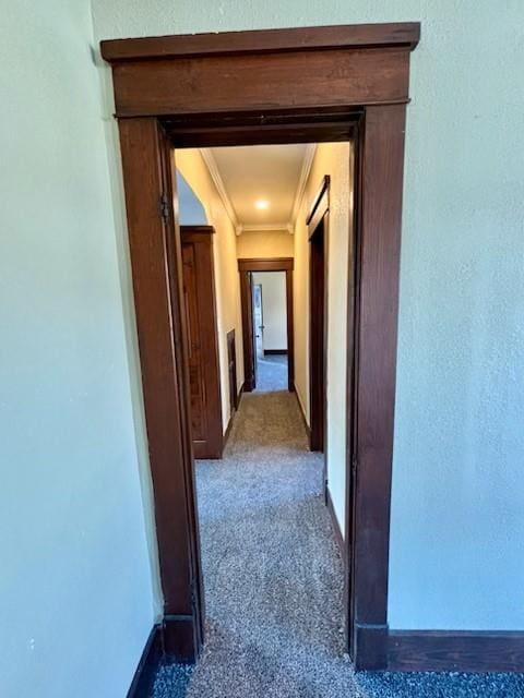 hall featuring dark colored carpet and ornamental molding