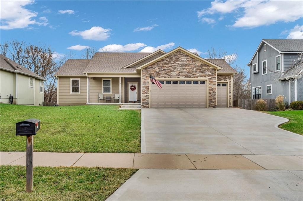 view of front of house with a front yard, a garage, and covered porch