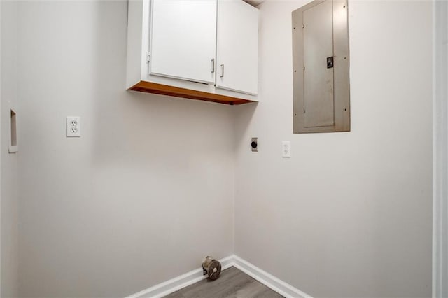 washroom featuring electric panel, wood-type flooring, cabinets, and hookup for an electric dryer