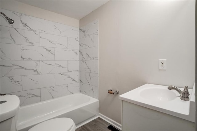 full bathroom with hardwood / wood-style floors, vanity, tiled shower / bath combo, and toilet