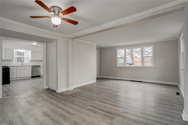 empty room featuring crown molding, light hardwood / wood-style flooring, ceiling fan, and sink