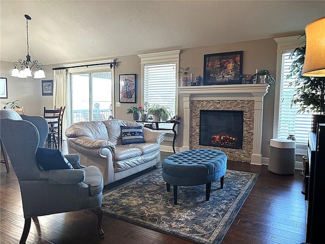 living room with a notable chandelier, dark hardwood / wood-style flooring, and a textured ceiling