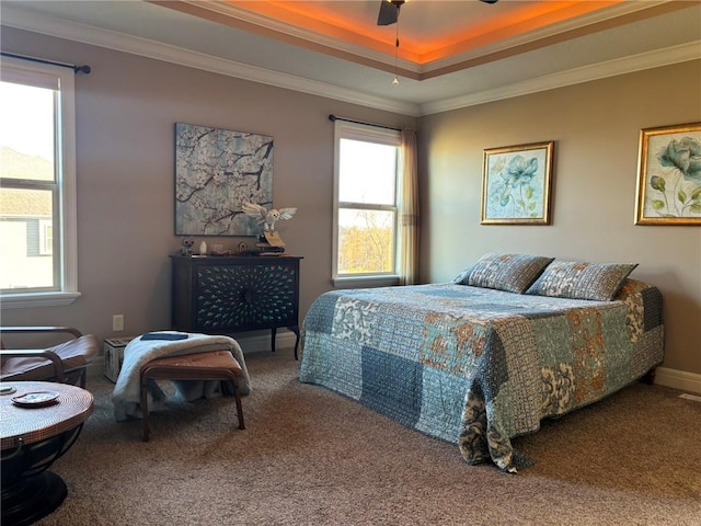 carpeted bedroom with a tray ceiling, ceiling fan, and ornamental molding