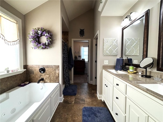 bathroom with a bathtub, vanity, and vaulted ceiling