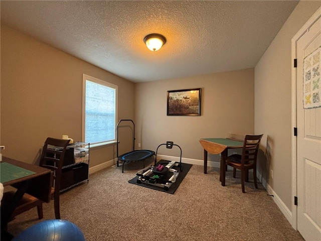 workout room featuring carpet flooring and a textured ceiling