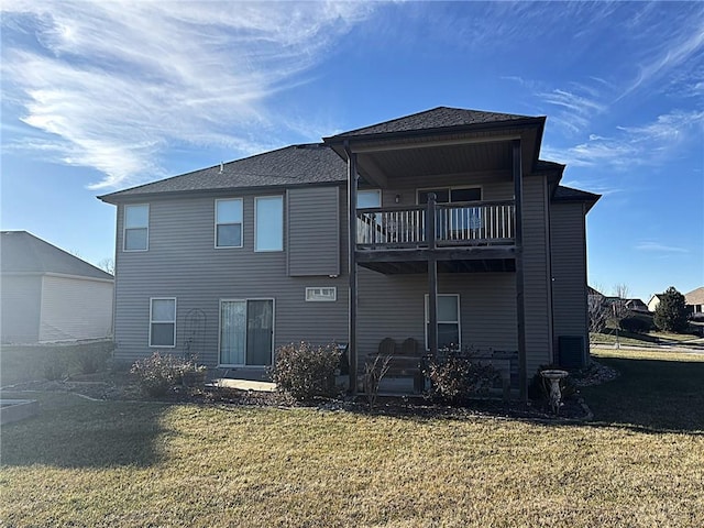 rear view of house with a yard and a balcony