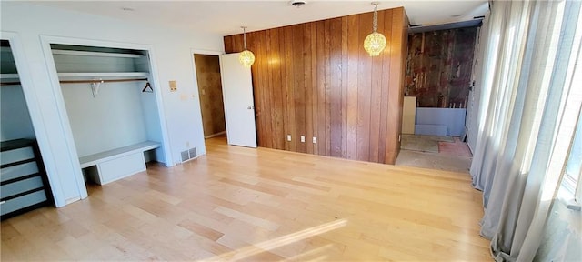 unfurnished bedroom featuring hardwood / wood-style flooring and two closets