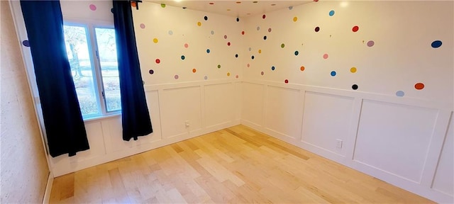 empty room with plenty of natural light and light hardwood / wood-style floors