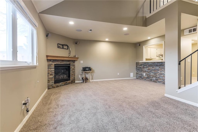 unfurnished living room featuring carpet flooring, lofted ceiling, and a fireplace