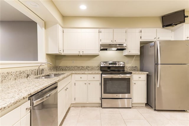 kitchen featuring light stone countertops, white cabinets, stainless steel appliances, sink, and light tile patterned flooring