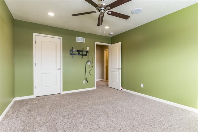 unfurnished bedroom with ceiling fan and light colored carpet