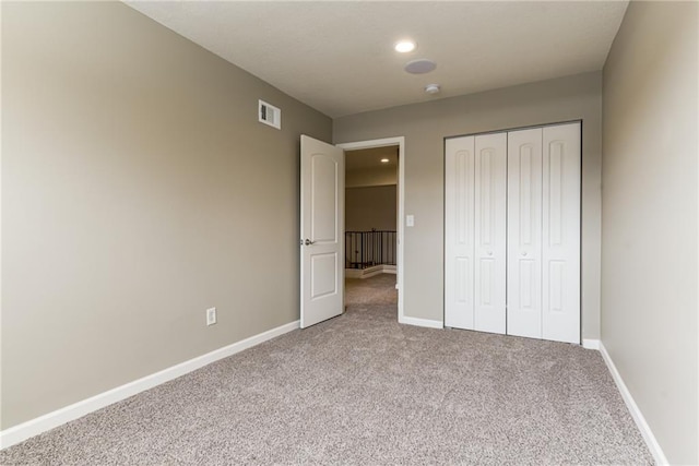 unfurnished bedroom featuring a closet and light carpet