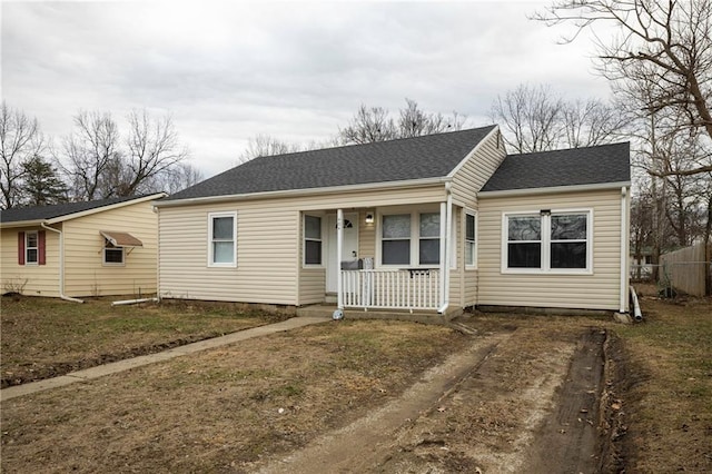 ranch-style house featuring covered porch and a front yard