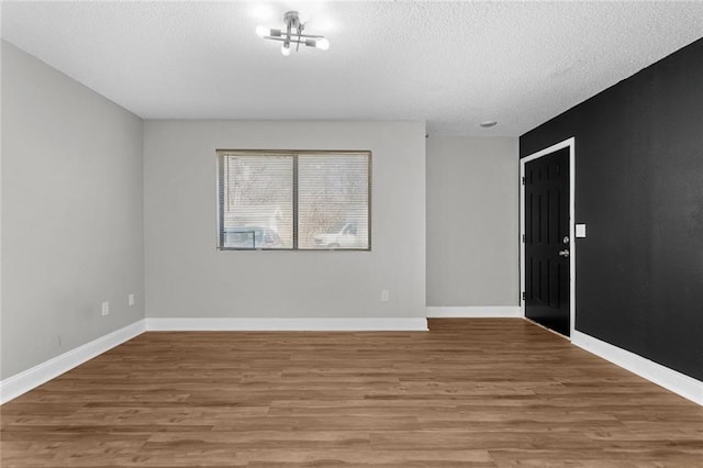 unfurnished room featuring hardwood / wood-style floors and a textured ceiling