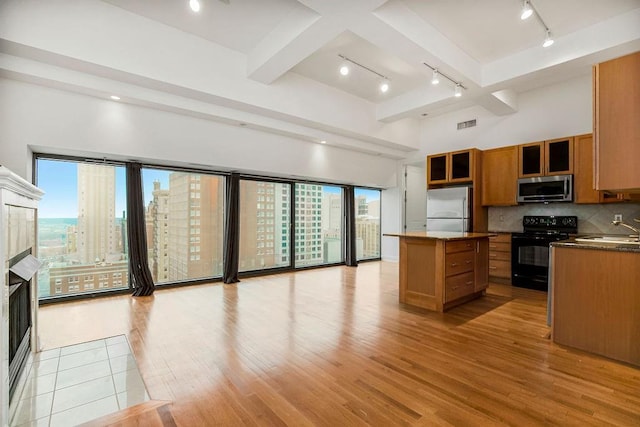 kitchen with plenty of natural light, a center island, stainless steel appliances, and a tile fireplace