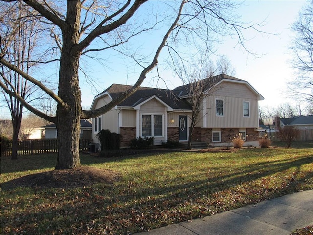 tri-level home featuring a front lawn and central air condition unit