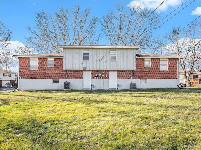 rear view of house featuring a lawn and central AC