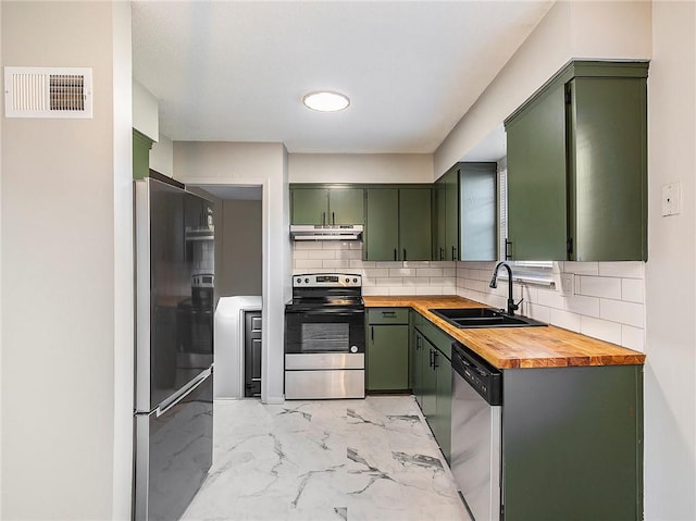 kitchen with butcher block counters, sink, stainless steel appliances, and green cabinetry