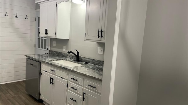 kitchen with light stone counters, dishwasher, white cabinets, and sink