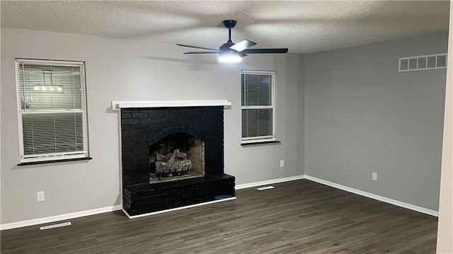 unfurnished living room with a fireplace, dark hardwood / wood-style flooring, a textured ceiling, and ceiling fan