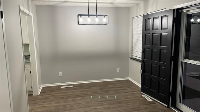 foyer entrance with a textured ceiling and dark hardwood / wood-style floors