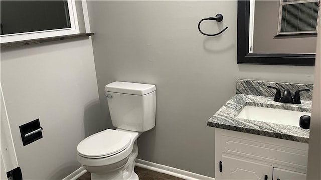 bathroom with hardwood / wood-style flooring, vanity, and toilet