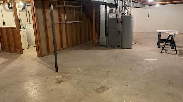 basement featuring washer and dryer, heating unit, and water heater