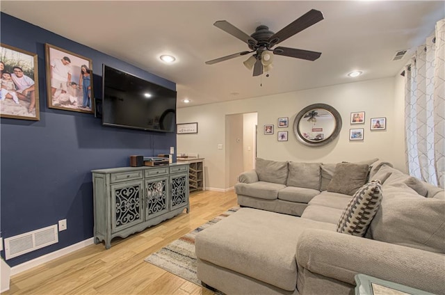 living room with light hardwood / wood-style flooring and ceiling fan