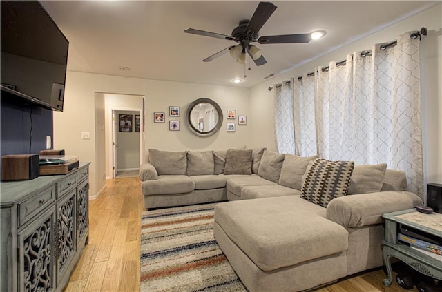 living room featuring light wood-type flooring and ceiling fan