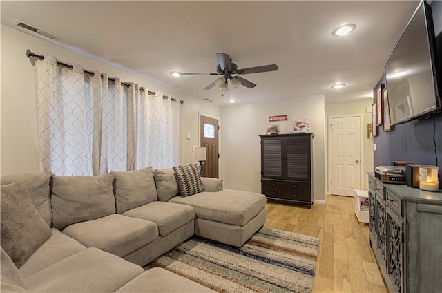 living room with light hardwood / wood-style flooring and ceiling fan