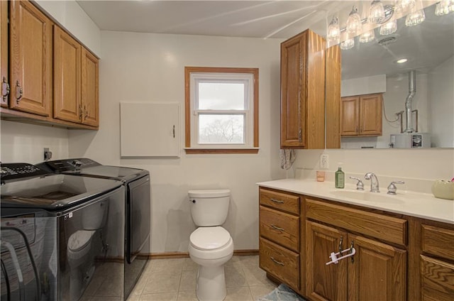 bathroom featuring tile patterned floors, toilet, sink, and washing machine and clothes dryer