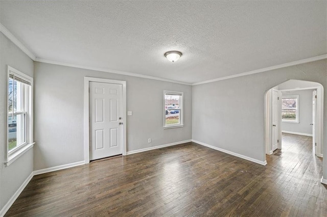 empty room with dark hardwood / wood-style floors, a healthy amount of sunlight, and ornamental molding