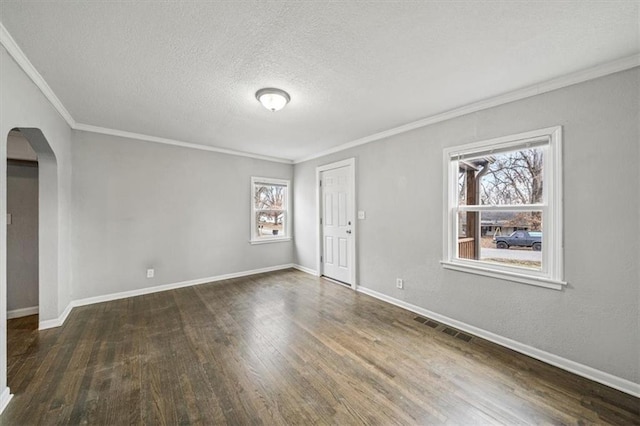 empty room featuring crown molding, dark wood-type flooring, and a textured ceiling