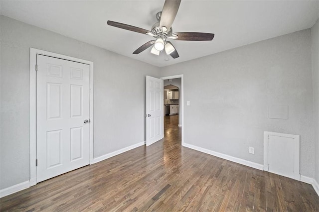 unfurnished bedroom featuring ceiling fan and dark wood-type flooring