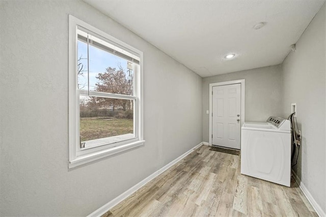 laundry area featuring washer and clothes dryer and light hardwood / wood-style flooring