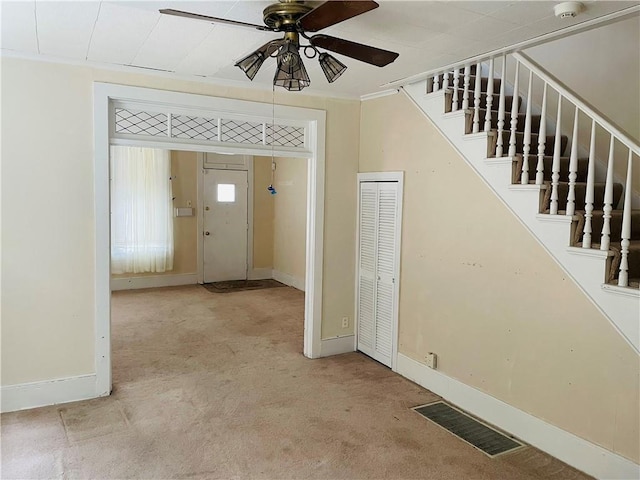 foyer entrance featuring carpet flooring and ceiling fan