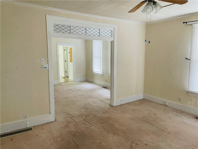 unfurnished room featuring light carpet, crown molding, and ceiling fan