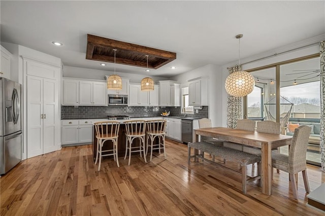 kitchen featuring a sink, a healthy amount of sunlight, appliances with stainless steel finishes, and a tray ceiling