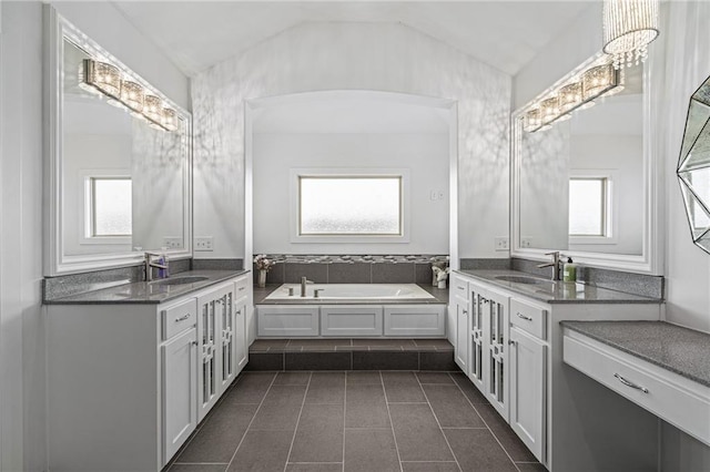 full bath featuring vaulted ceiling, a healthy amount of sunlight, and a sink