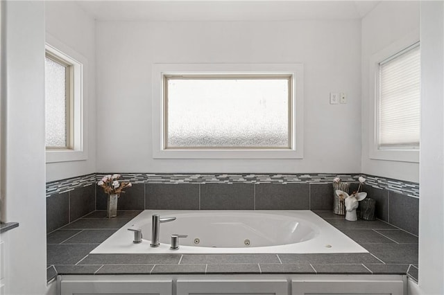 bathroom featuring a tub with jets and plenty of natural light