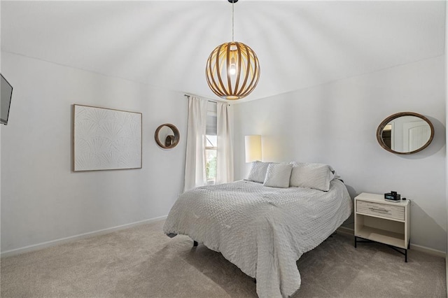 carpeted bedroom featuring an inviting chandelier and baseboards