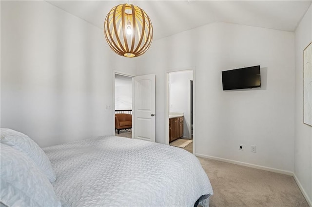 bedroom with lofted ceiling, a chandelier, connected bathroom, light colored carpet, and baseboards