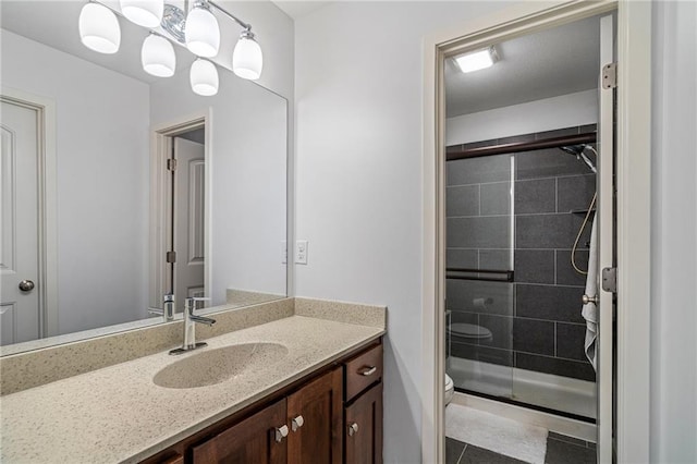 bathroom with a stall shower, vanity, toilet, and tile patterned floors