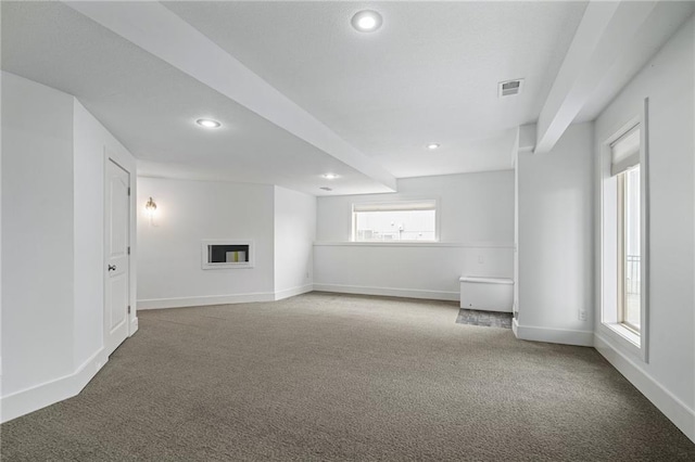 carpeted empty room featuring visible vents, a fireplace, baseboards, and recessed lighting