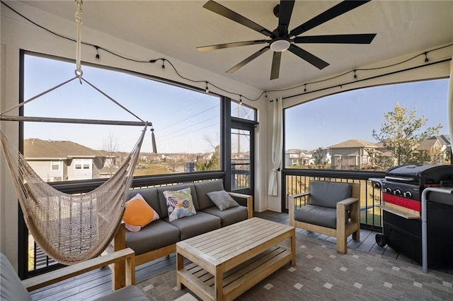 sunroom / solarium with ceiling fan and a residential view