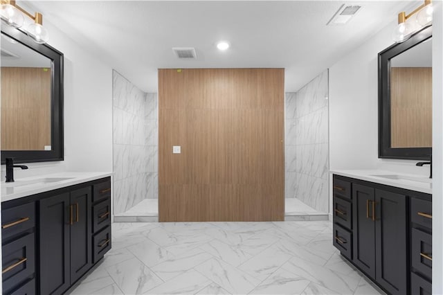 bathroom featuring marble finish floor, two vanities, a sink, and a marble finish shower