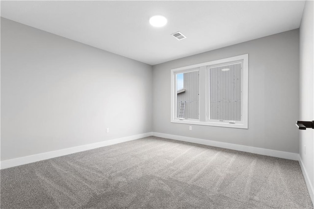 carpeted spare room featuring baseboards and visible vents